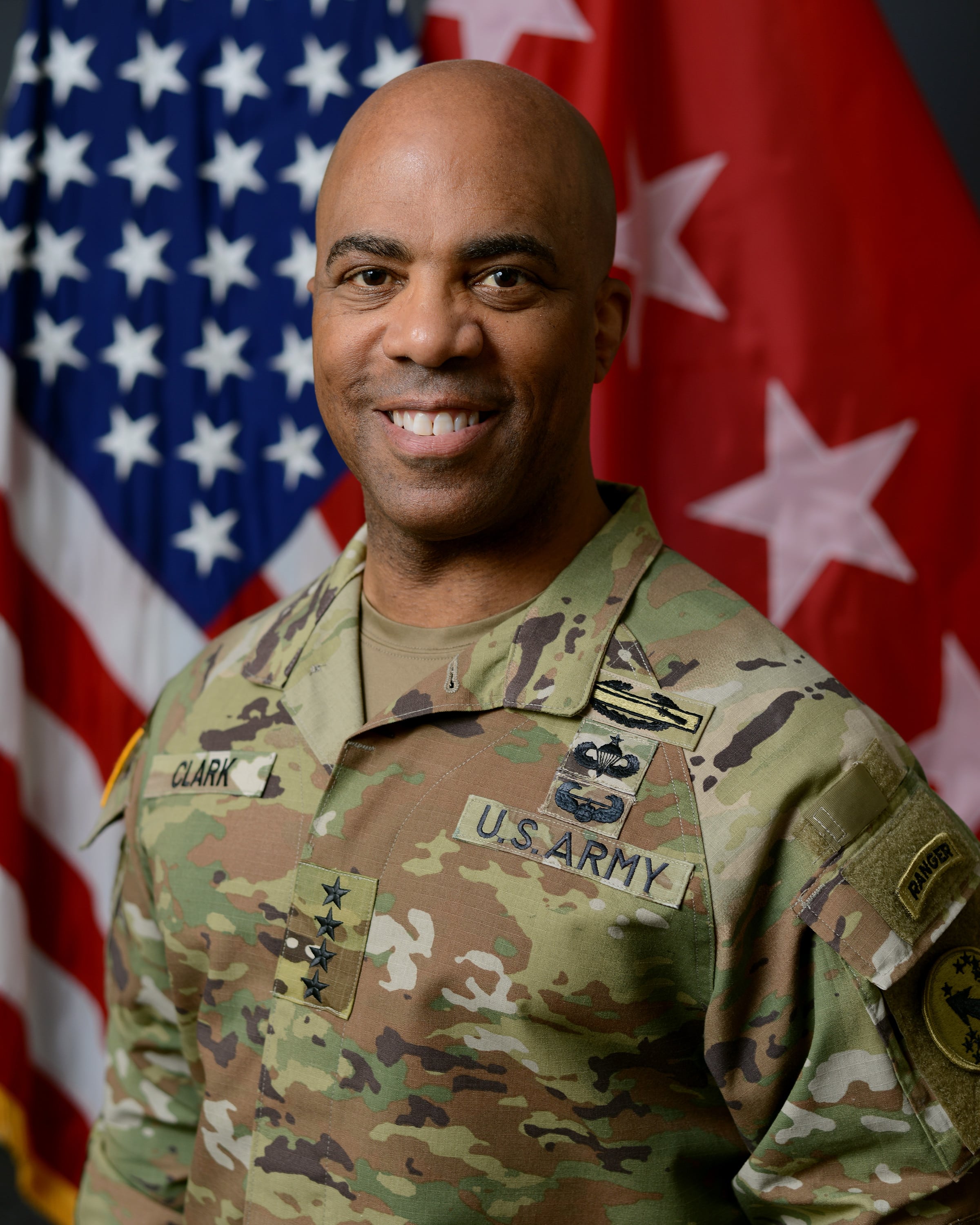 El general Ronald P. Clark posa con uniforme militar de campaña frente a la bandera de Estados Unidos en Fort Shafter. (Infobae América)