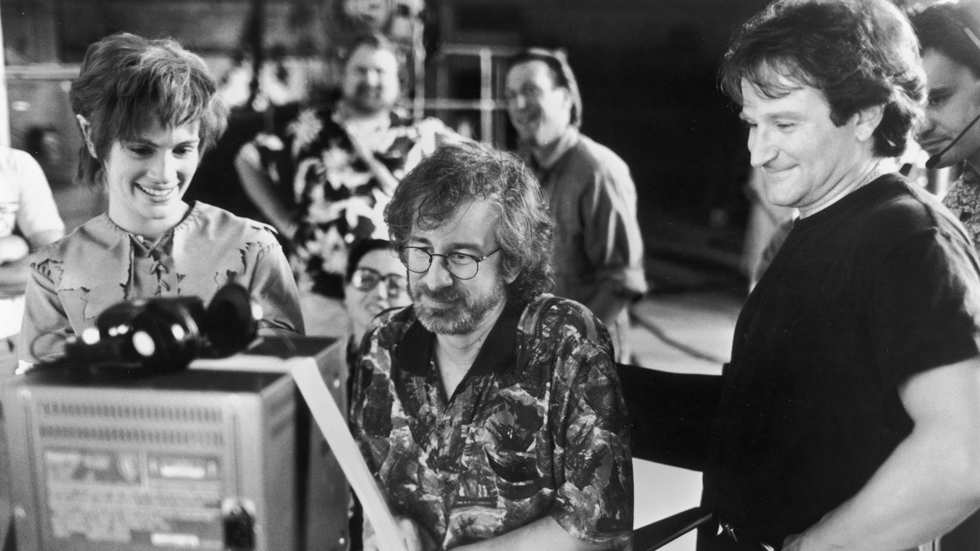 Actors Julia Roberts and Robin Williams watch daily production footage with director Steven Spielberg on the set of his film,