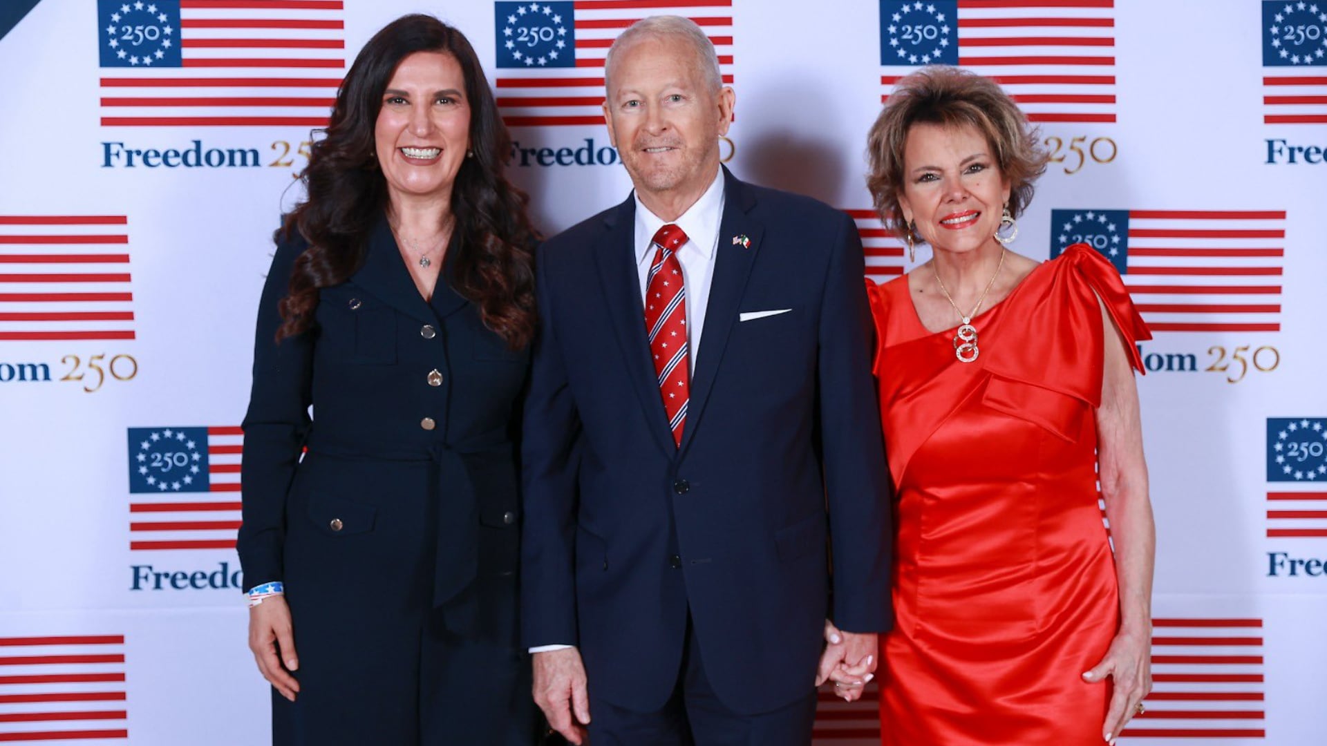 Kenia López Rabadán, Ronald Johnson y una mujer posan durante el evento del 250 aniversario de Estados Unidos. (@kenialopezr)