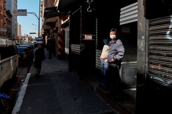 Personas con tapabocas caminan frente