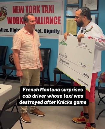 Dos hombres de pie; uno sostiene un cheque gigante de GoFundMe de $75,000, el otro lo mira sonriendo. Detrás, un cartel de 'New York Taxi Worker Alliance'