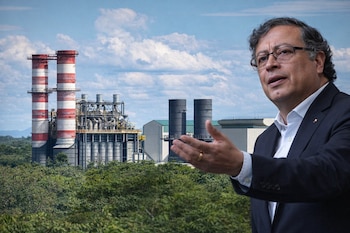 Primer plano de Gustavo Petro gesticulando, con una termoeléctrica de grandes chimeneas rojas y blancas, rodeada de árboles verdes bajo un cielo azul nublado.