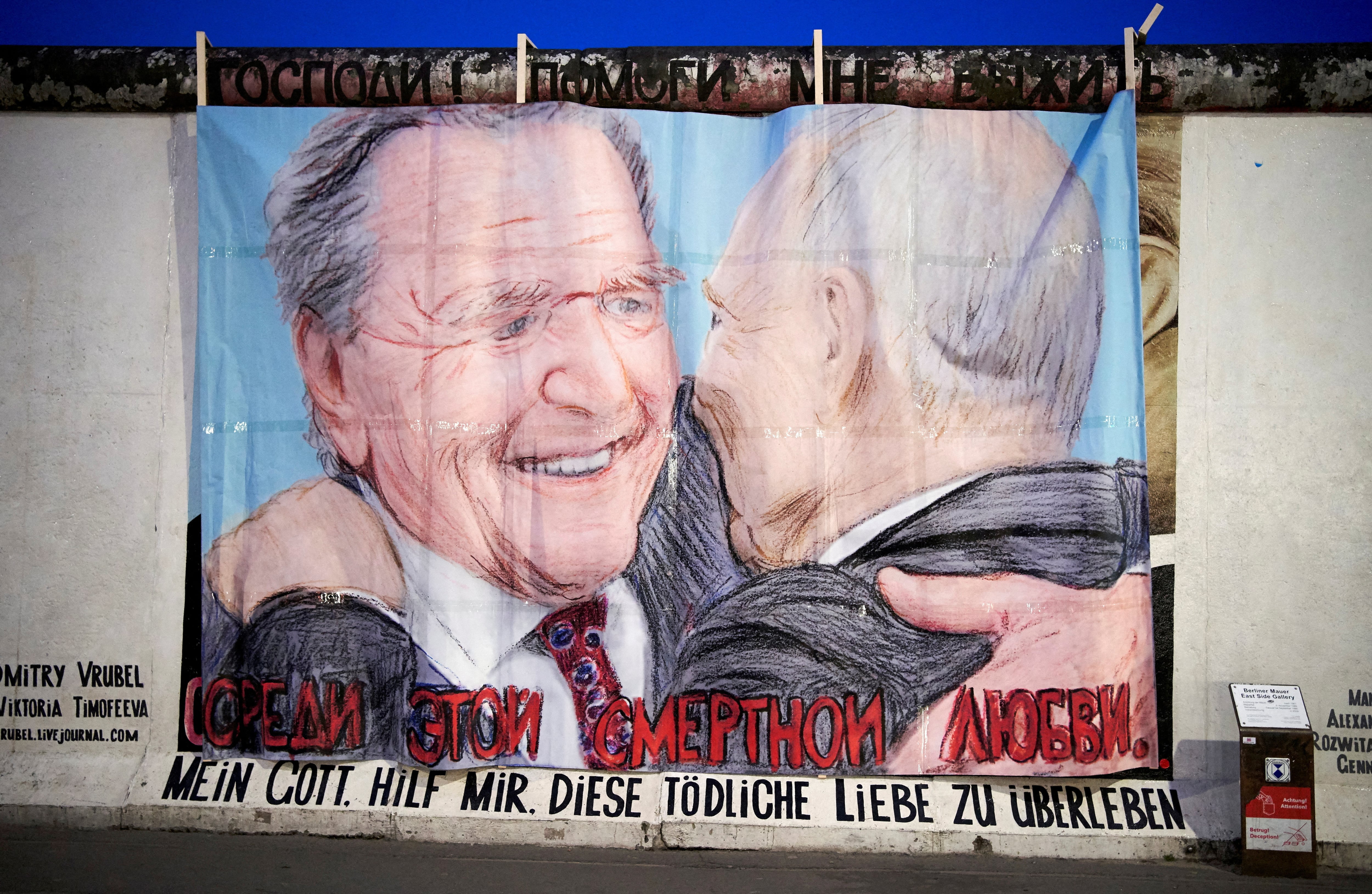 El excanciller alemán Gerhard Schröder y el presidente ruso Vladimir Putin aparecen representados dándose un beso en la East Side Gallery de Berlín, Alemania, el 2 de abril de 2022. El lema, en alemán y ruso, dice: «Dios mío, ayúdame a sobrevivir a este amor». Fotografía tomada durante una campaña artística el 2 de abril de 2022. REUTERS/Anne Barth/Foto de archivo