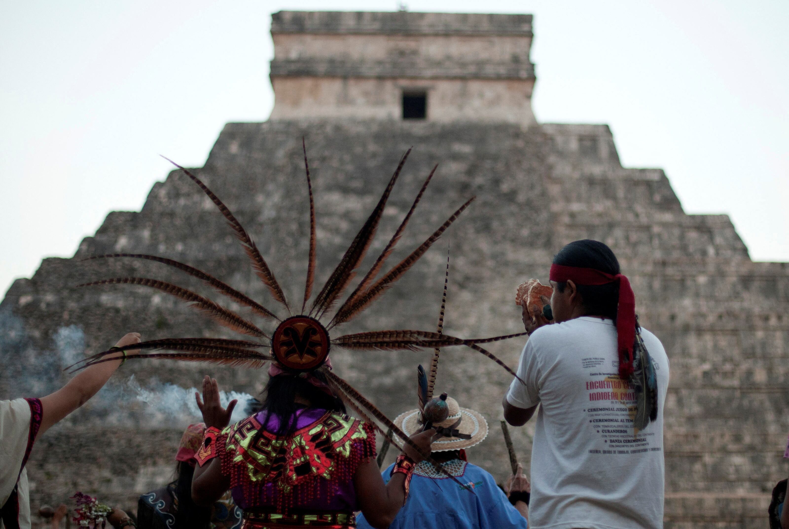 FILE PHOTO: A group of people wearing pre-Hispanic costumes perform a ritual near the pyramid of Kukulkan at the archaeological zone of Chichen Itza in Yucatan State, December 21, 2012. REUTERS/Victor Ruiz/File Photo