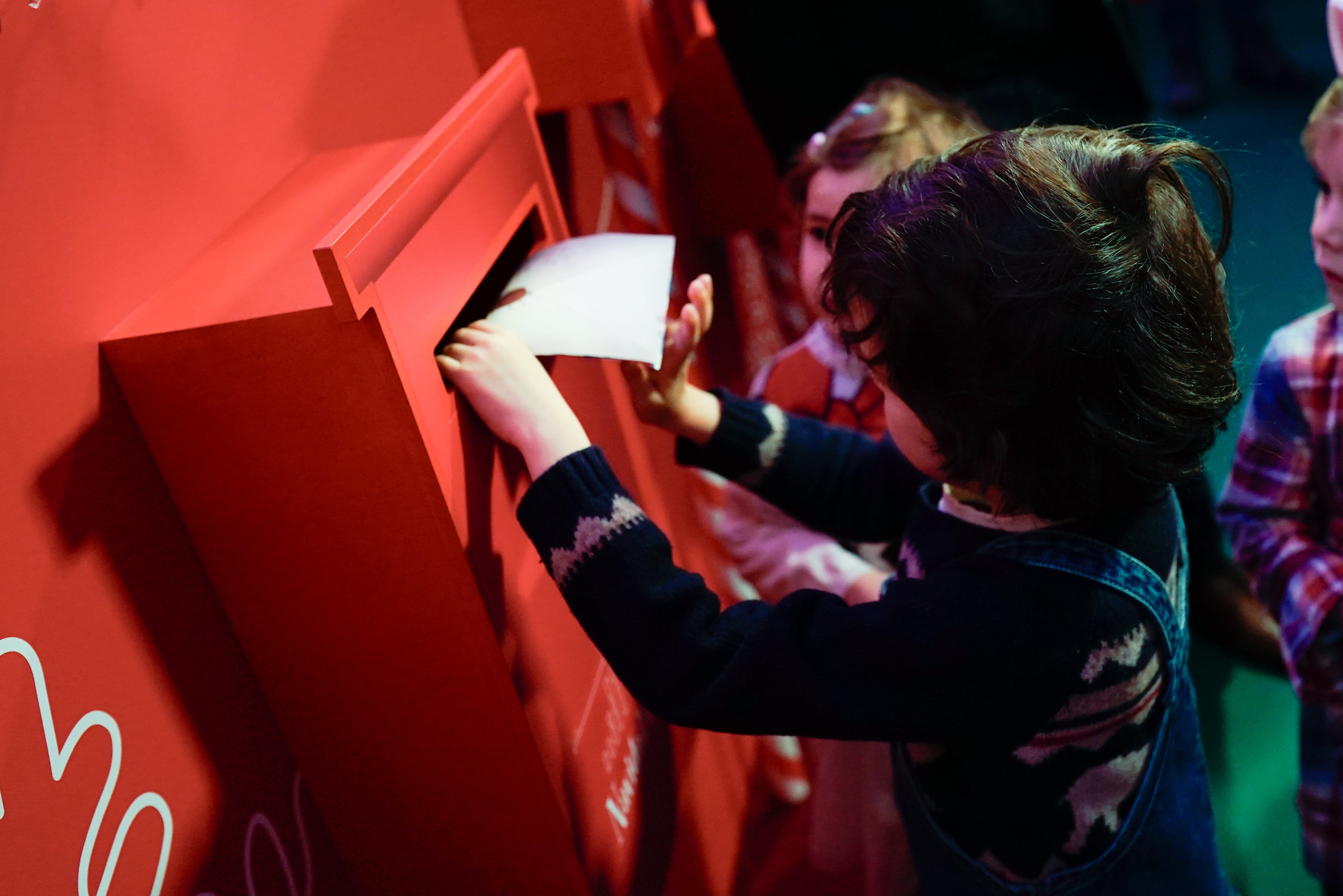 Niños entregando sus cartas a los Reyes Magos en un buzón habilitado por la Comunidad de Madrid