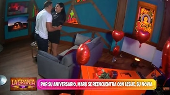 Mark Vito abraza a una mujer, Leslie, en una habitación decorada con globos rojos en forma de corazón y un ramo de rosas sobre una mesa