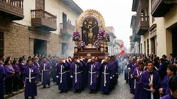 Personas con túnicas moradas cargan un anda con una pintura religiosa entre una multitud reunida en una calle empedrada con balcones de madera.