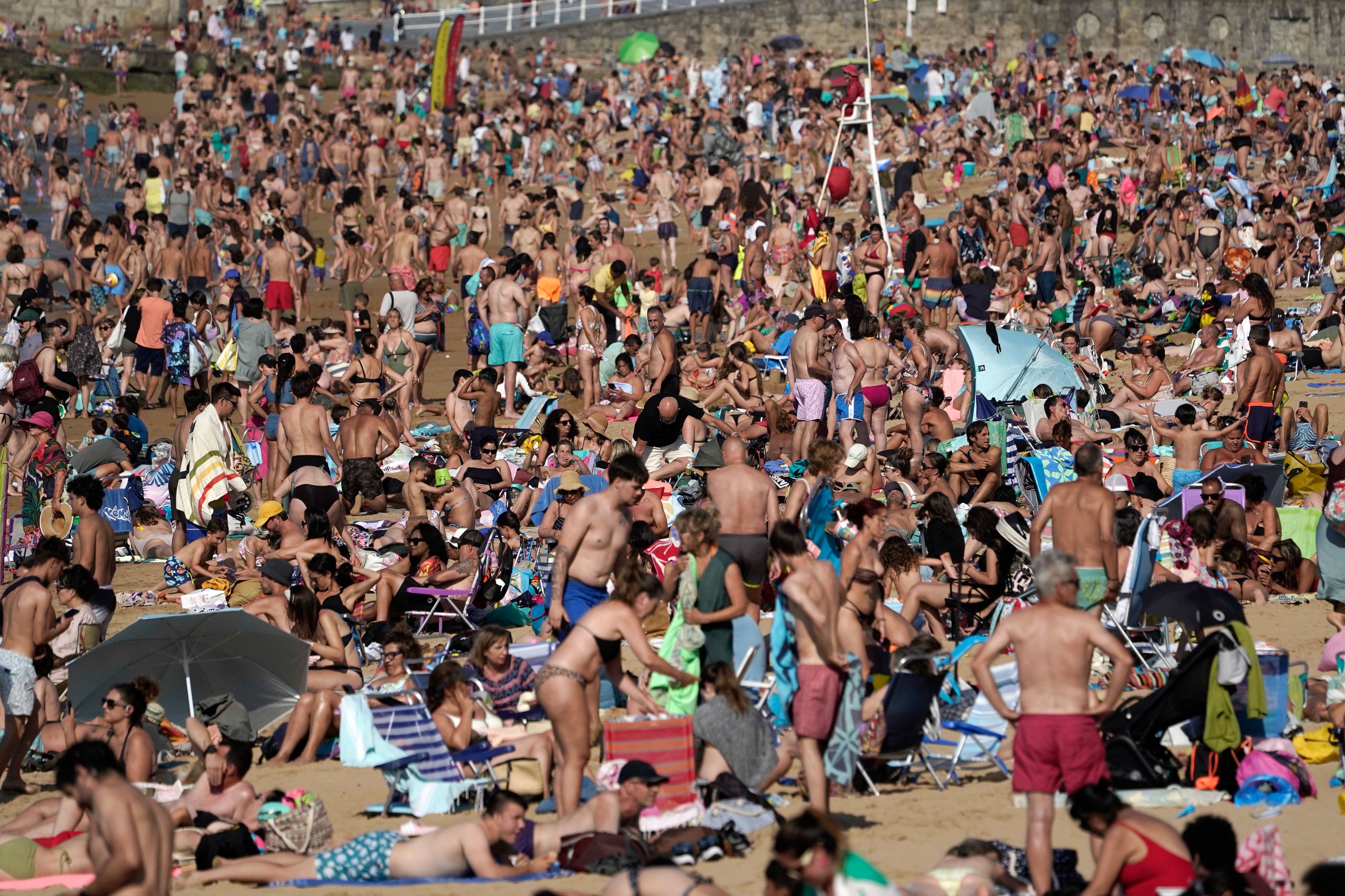 Bañistas y paseantes en la playa de San Lorenzo de Gijón a 16 de julio de 2025. (EFE/Paco Paredes)
