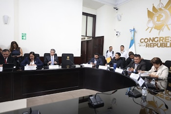 Cuatro mujeres sentadas en una mesa con micrófonos y placas con sus nombres en un salón del Congreso de la República