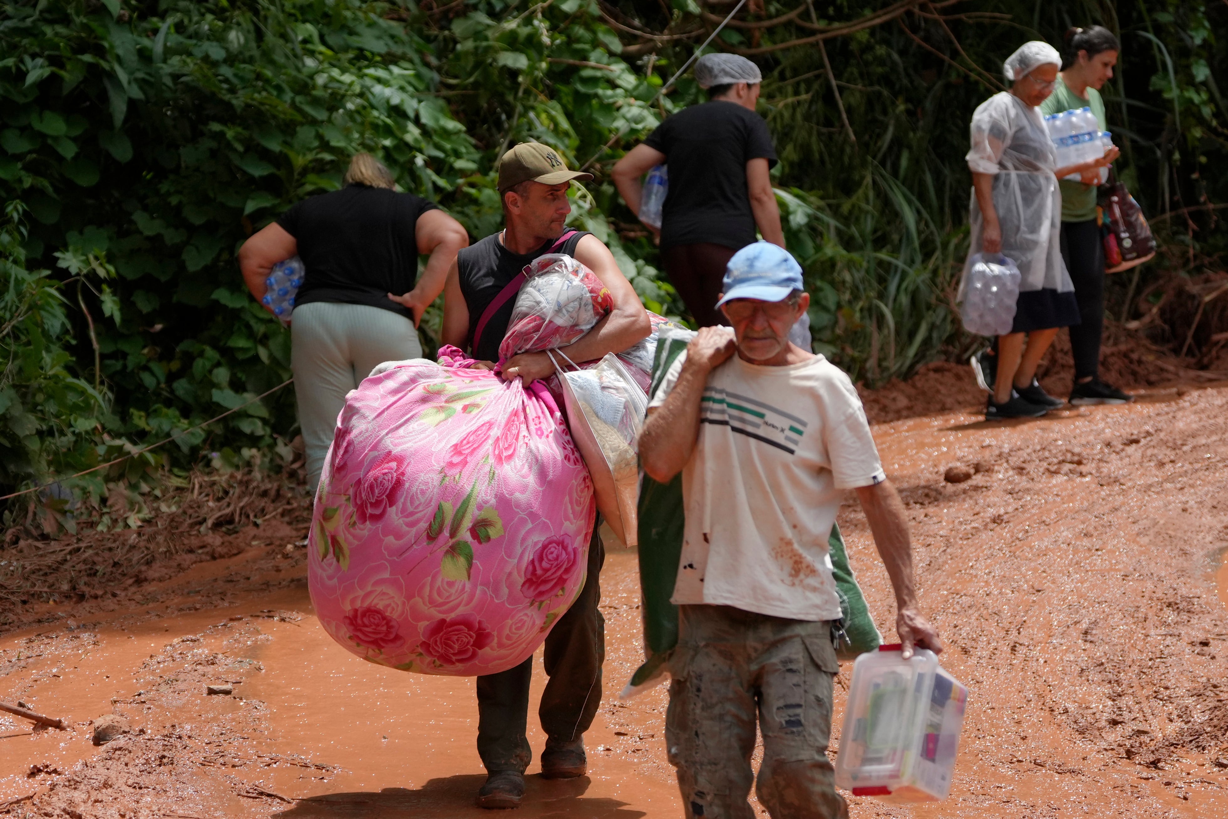 Residentes cerca del lugar donde las inundaciones destruyeron casas, en el vecindario Parque Burnier de la ciudad de Juiz de Fora, estado de Minas Gerais, Brasil, el 25 de febrero del 2026
(AP foto/Silvia Izquierdo)