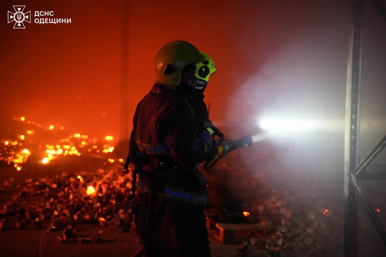 un bombero intenta sofocar el incendio en la región de Odesa mientras un rodado ilumina el sector (Servicio Estatal de Emergencias de Ucrania)