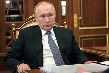 Russian President Vladimir Putin listens
