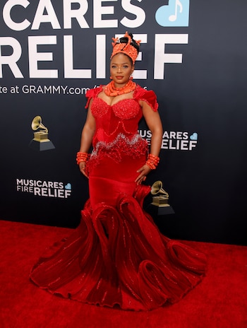 La cantante nigeriana Yemi Alade con un vestido rojo de diseño estructurado y detalles ondulados en la falda