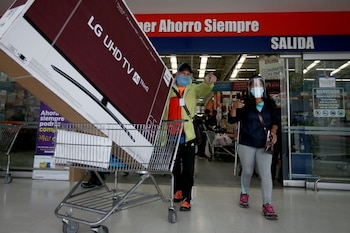 Compradores utilizando una mascarilla salen