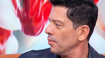 Rostro de perfil de un hombre con cabello oscuro y chaqueta de cuero negra sobre un fondo difuminado.