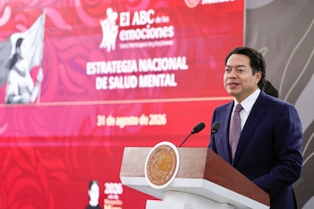 Un hombre con traje habla ante un podio con el escudo de México y una pantalla red de fondo sobre la Estrategia Nacional de Salud Mental