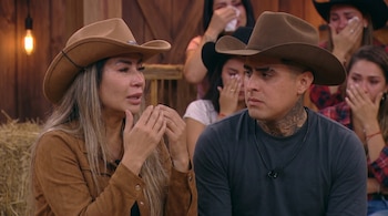 Pamela López llorando con sombrero vaquero marrón, junto a un hombre con tatuajes en el cuello y sombrero oscuro. Otros participantes tristes en el fondo.