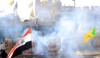 Manifestantes tratan de lanzar proyectiles desde el exterior del predio de la sede diplomática de EEUU en Bagdad, mientras banderas de Irak y la que identifica al grupo terrorista Hezbollah, ondean en la zona (REUTERS/Thaier al-Sudani)