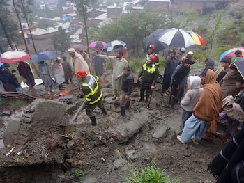 En esta imagen proporcionada por el Servicio de Rescate 1122 del Departamento de Emergencias, socorristas y civiles retiran escombros de una casa dañada parcialmente por un deslave causado por una tormenta en Matta, un poblado en el valle de Swat, en Pakistán, el domingo 14 de abril de 2024. (Servicio de Rescate 1122 del Departamento de Emergencias vía AP)