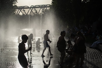 Varias personas se refrescan en las fuentes de Madrid Río, a 23 de junio de 2026, en Madrid (España). (Fernando Sánchez/Europa Press)