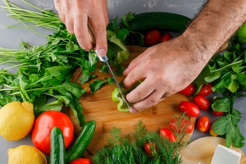 Un hombre preparando varias verduras (Magnific)