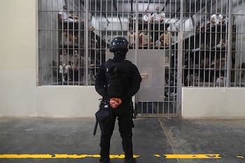 Un policía monta guardia junto a los reclusos dentro de una cárcel durante una visita de prensa al Centro de Confinamiento por Terrorismo (CECOT), en Tecoluca, El Salvador, el 4 de abril de 2025. REUTERS/Jose Cabezas