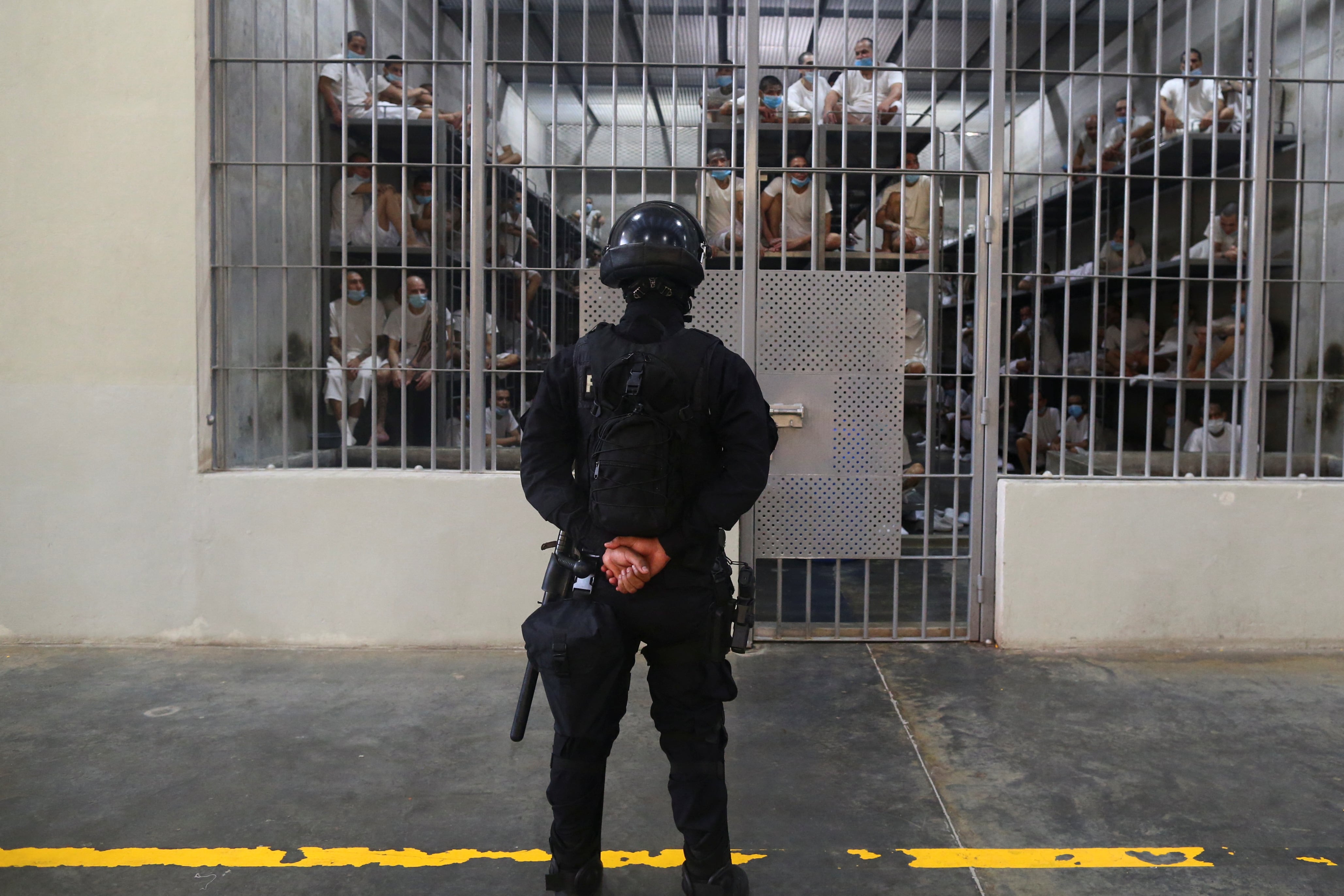 Un policía monta guardia junto a los reclusos dentro de una cárcel durante una visita de prensa al Centro de Confinamiento por Terrorismo (CECOT), en Tecoluca, El Salvador, el 4 de abril de 2025. REUTERS/Jose Cabezas