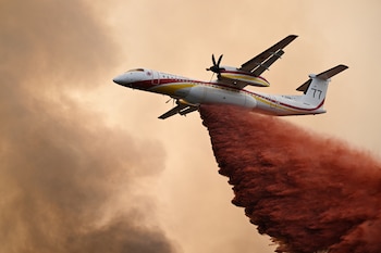Un De Havilland Canada Dash 8-400 arroja retardante de incendios sobre un bosque cerca de Saint-Jean-d'Illac, durante los incendios forestales en el suroeste de Francia, el martes 28 de julio de 2026 (AP/Emma Da Silva)