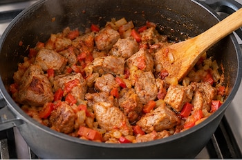 Un almuerzo completo con cerdo, papas, guiso y el toque dulce del plátano maduro - crédito VisualesIA