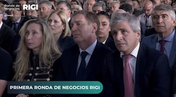 Asistentes sentados en un auditorio durante un acto público, entre ellos dos hombres con traje y una mujer con vestimenta oscura