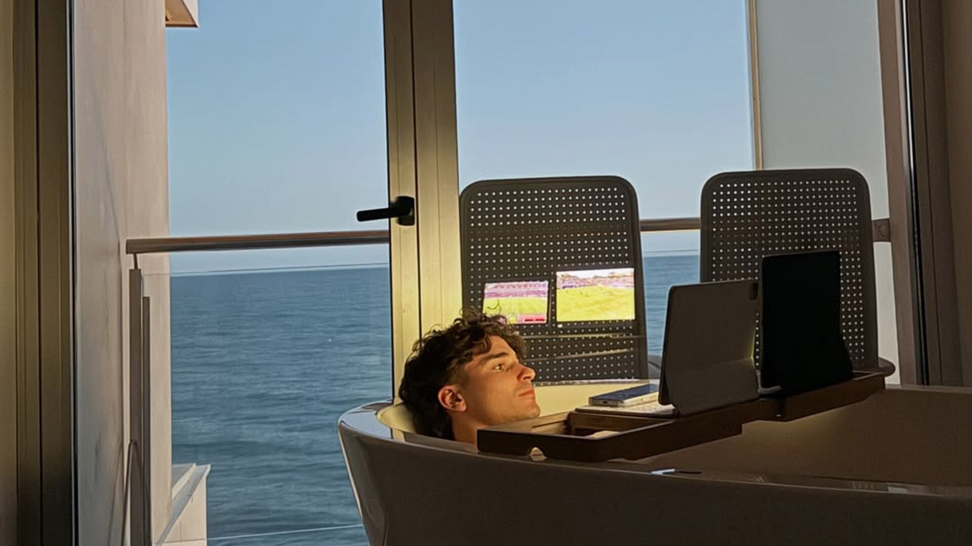 Julián Álvarez en uno de sus días de relax en una bañera mirando un partido de fútbol en la tablet (Instagram @juliaanalvarez)
