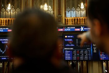FOTO DE ARCHIVO: Un grupo de personas observando los paneles electrónicos que muestran información bursátil en la Bolsa de Madrid, España. 7 de abril de 2025. REUTERS/Susana Vera