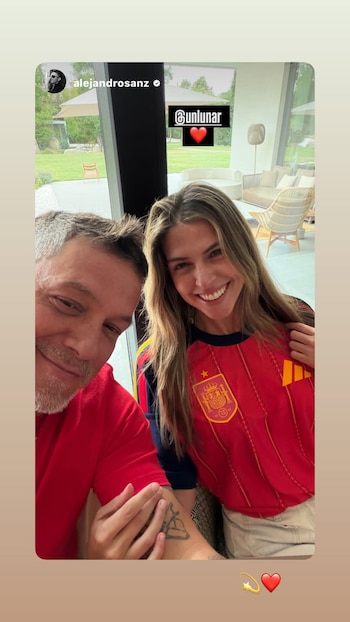 Primer plano de Alejandro Sanz y Stephanie Cayo sonriendo; ella viste una camiseta de la selección española