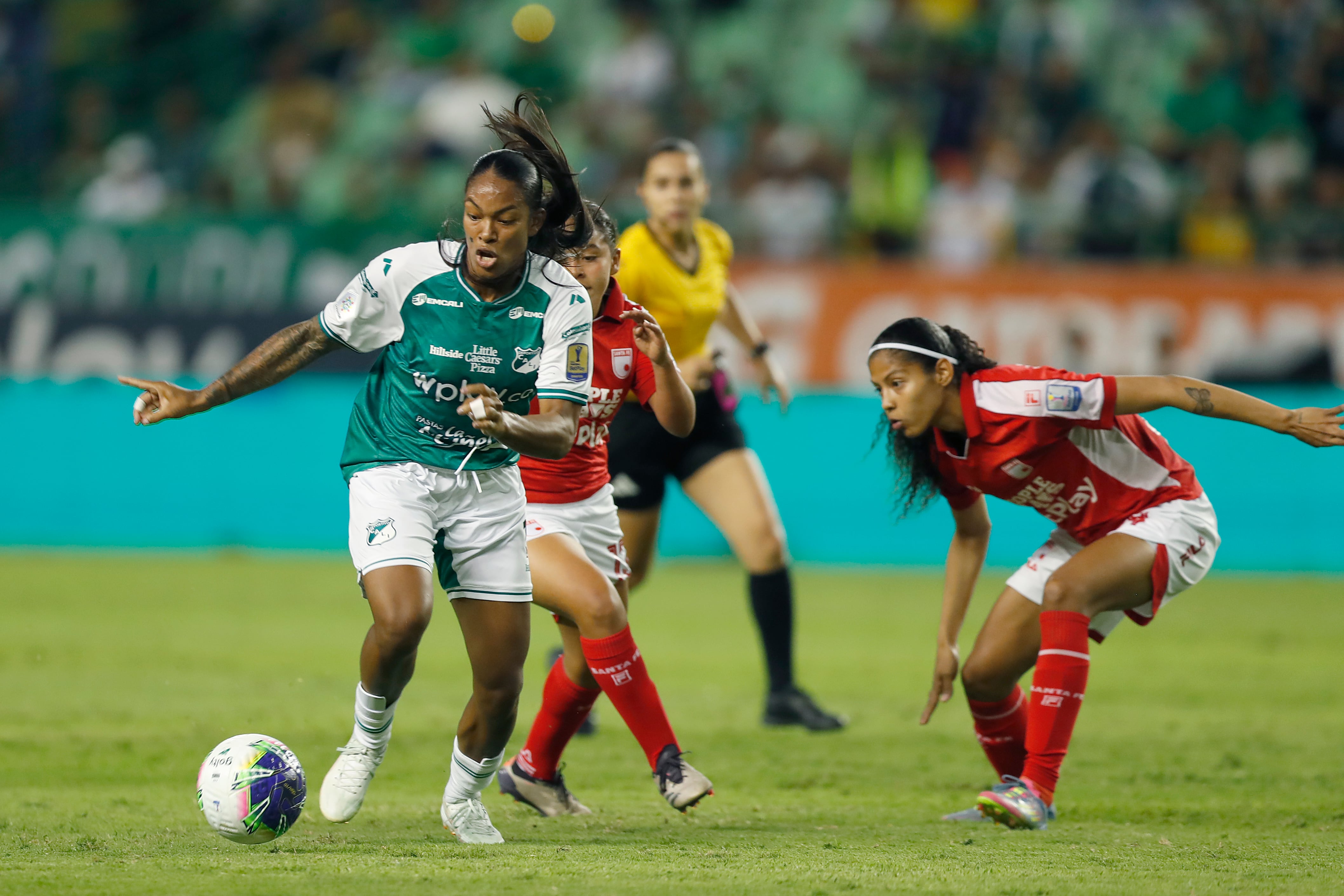 Melanin Aponzá (i), del Deportivo Cali, disputa el balón con Isis De La Cruz (c), de Independiente Santa Fe, durante el partido de vuelta de la final de la Liga Profesional Femenina de Colombia entre Deportivo Cali e Independiente Santa Fe en el estadio Deportivo Cali, en Cali (Colombia). EFE/Ernesto Guzmán