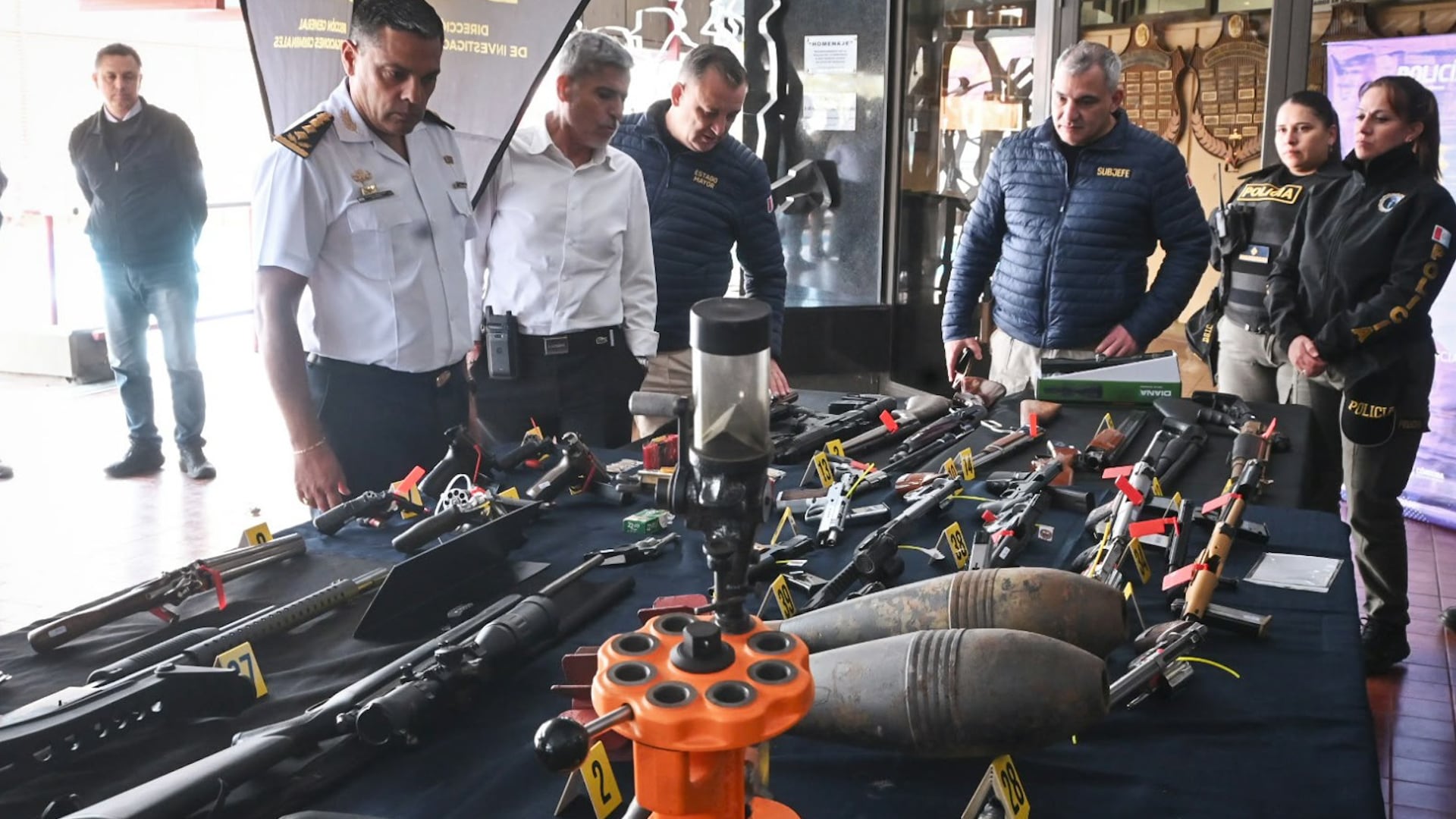Las armas de fuego y municiones incautadas sobre una mesa durante el procedimiento de la Policía de la provincia de Córdoba