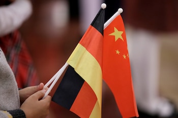 Un estudiante sostiene banderas de China y Alemania antes de una ceremonia de bienvenida ofrecida por el presidente chino, Xi Jinping, al presidente alemán, Frank-Walter Steinmeier (REUTERS/Jason Lee/Foto de archivo)