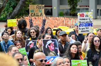 Manifestantes sostienen fotografías del fallecido líder de izquierda Carlos Pizarro, asesinado en 1990, durante una protesta frente al Museo Nacional en Bogotá, el 17 de octubre de 2026