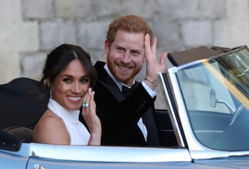 El príncipe Harry y su esposa Meghan Markle (I), duques de Sussex, abandonan el castillo en Windsor el 19 de mayo de 2018 tras su boda.(POOL/AFP - Steve Parsons)