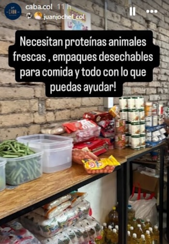Estantería con frijoles verdes, recipientes de plástico, salchichas, latas apiladas, bolsas de arroz y botellas de aceite. Fondo de pared de ladrillo