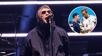 Hombre con gafas y chaqueta oscura canta en micrófono en escenario oscuro. Burbuja circular a la derecha muestra a dos futbolistas, uno de camiseta negra y otro blanca.