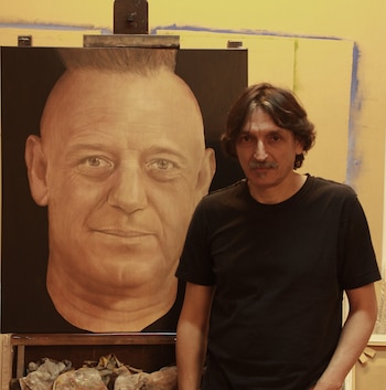 Santiago Raffo posa junto a un retrato que le hizo a Ricardo Iorio y se lo regaló antes de un show de Almafuerte
