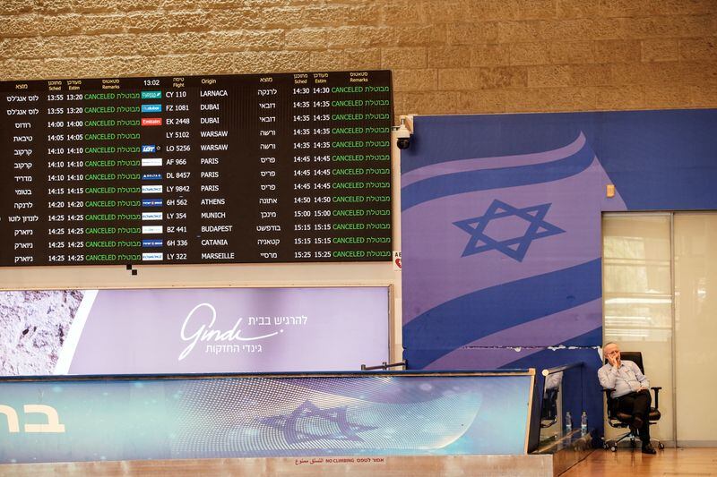 Un empleado del aeropuerto internacional Ben Gurion, sentado en la terminal de llegadas mientras se indica la cancelación de todos los vuelos desde y hacia el aeropuerto, tras un ataque israelí nocturno contra Irán, en Lod, cerca de Tel Aviv, Israel 13 de junio de 2025. (REUTERS/Tomer Appelbaum)