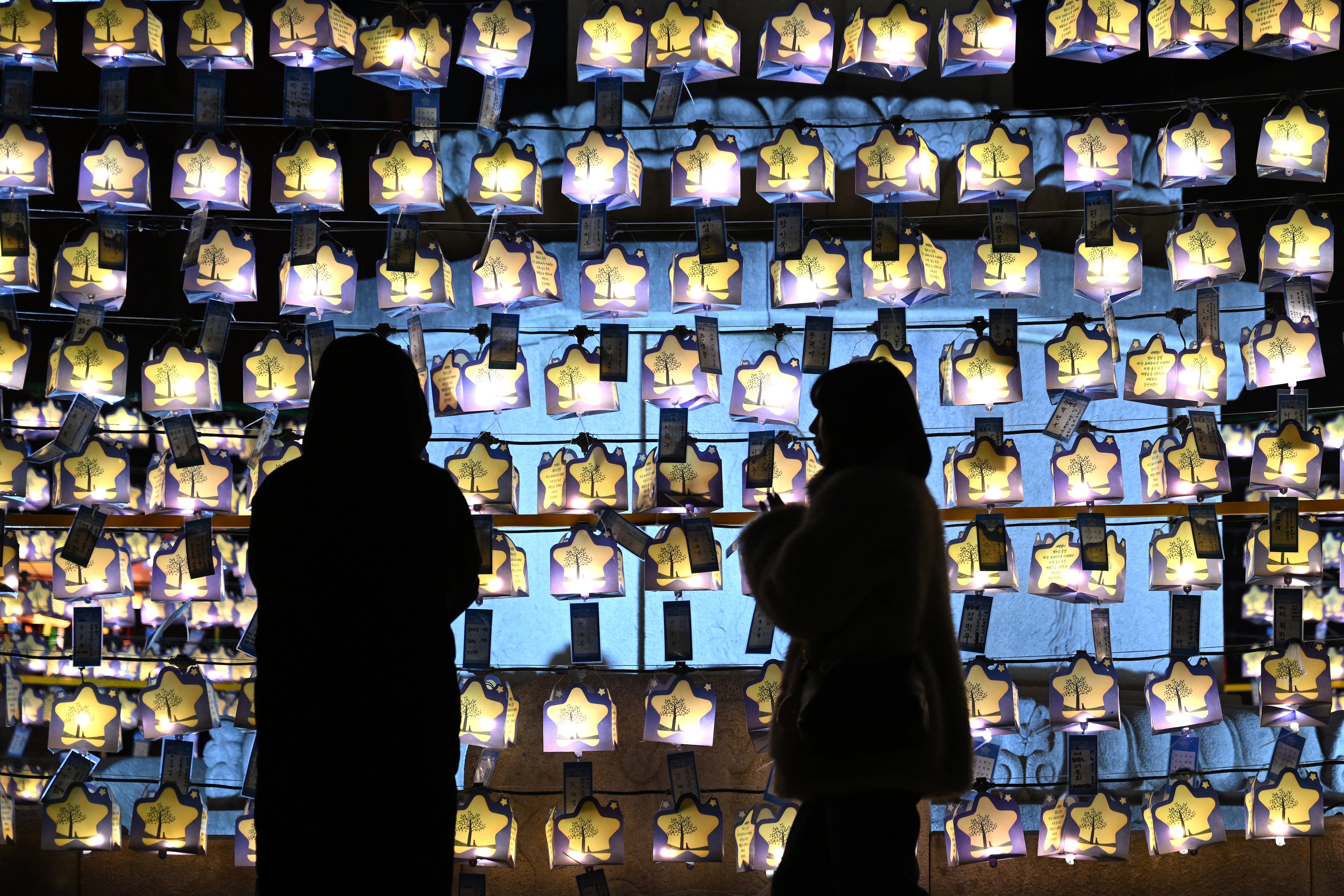 Visitantes rezan frente a linternas con deseos de Año Nuevo en el templo Jogyesa en el centro de Seúl. Seúl, 31 de diciembre de 2025. (Foto: Jung Yeon-je / AFP)