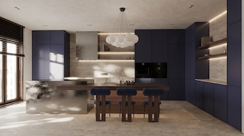 Cocina moderna con gabinetes azul oscuro, isla con base metálica y tope de madera, tres taburetes, campana extractora, horno, ventanas con persianas.