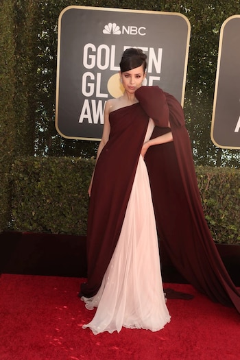 Sofia Carson optó por un vestido bicolor en bordó y rosa pastel de seda y tul con un moño XL en uno de sus hombros. Completó su look con aros de brillantes y peinado recogido