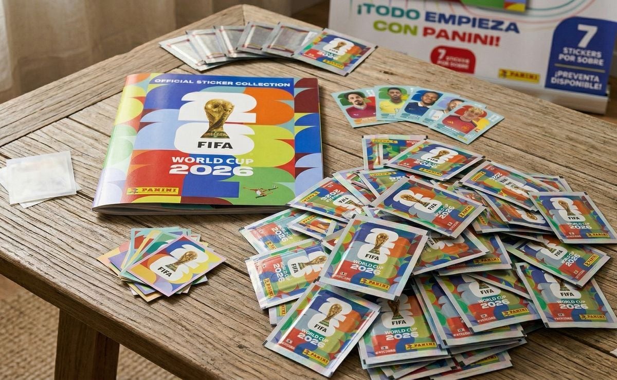 El álbum oficial de figuritas Panini FIFA World Cup 2026, junto con numerosos sobres y figuritas sueltas, se exhiben en una mesa de madera, listos para coleccionistas. (Redes sociales)
