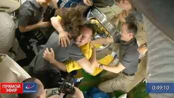 In this frame grab from video provided by Roscosmos, the crew of the International Space Station welcomes three Russian cosmonauts, dressed in yellow, after the new arrivals docked, Friday, March 18, 2022. The cosmonauts emerged from the Soyuz capsule wearing yellow flight suits with blue stripes, the colors of the Ukrainian flag. (Roscosmos via AP)