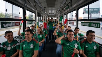 Un grupo de personas mexicanas, muchas con camisetas verdes de fútbol, celebrando en un autobús en Monterrey, con banderas, vuvuzelas y carteles de "VAMOS MÉXICO".