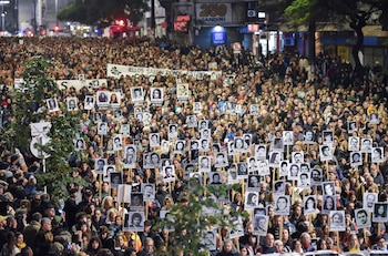 Personas marchan con retratos de