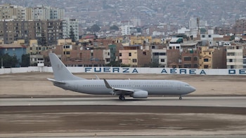 Avión Boeing 737-800NG gris de la Fuerza Aérea del Perú, con número 357 en la cola, en pista. Al fondo, edificios urbanos y valla con "Fuerza Aérea de"
